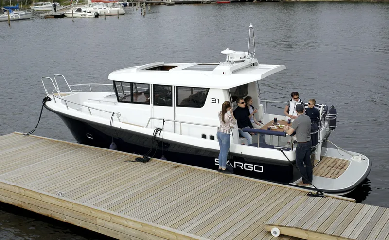 Slide: The Image of 2024 Sargo 31 boat docked with people onboard, enjoying a gathering. - 18