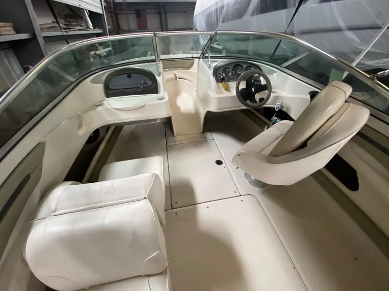 Slide: The Image of Interior of 2005 Sea Ray 200 Sport boat with white seating and steering console. - 4