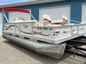Slide: The Image of 2006 Crest Super Sport pontoon boat with red canopy, parked on trailer. - 2
