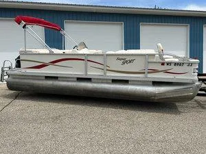 Slide: The Image of 2006 Crest Super Sport pontoon boat with red canopy, parked on pavement. - 4