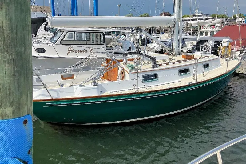 Slide: The Image of 1987 Morris Linda sailboat docked in a marina, featuring a green hull and white deck. - 2