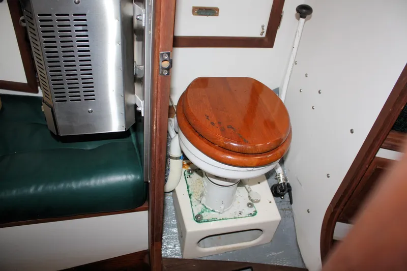 Slide: The Image of 1987 Morris Linda boat interior with wooden toilet seat and green seating. - 30
