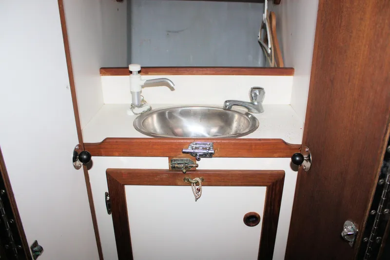 Slide: The Image of 1987 Morris Linda boat interior with compact sink and wooden cabinetry. - 31