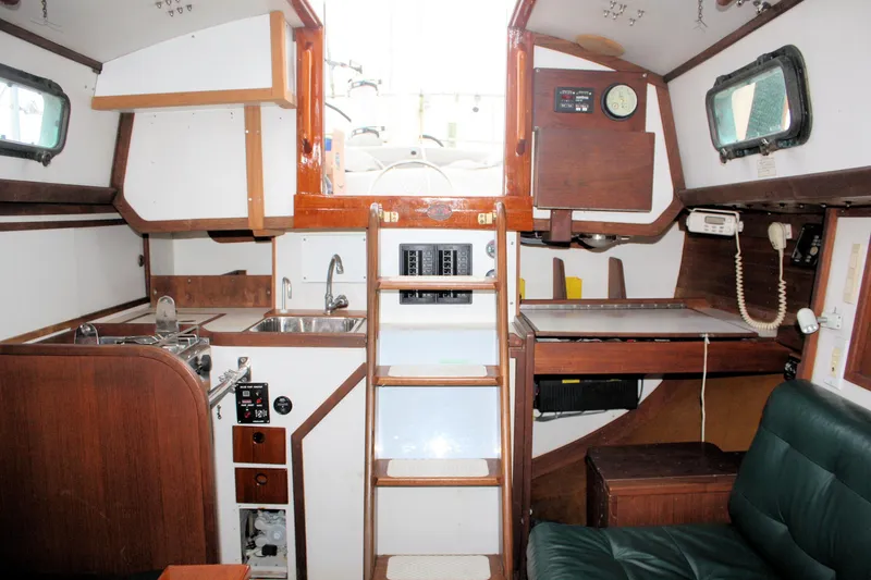 Slide: The Image of Interior of 1987 Morris Linda sailboat with wooden cabinetry and compact kitchen area. - 33