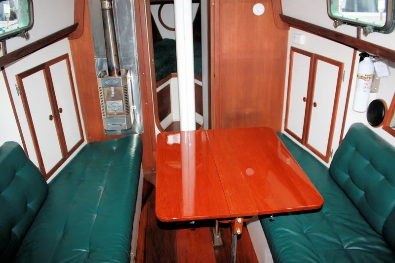 Slide: The Image of Interior of 1987 Morris Linda boat with wooden table and green cushioned seating. - 38