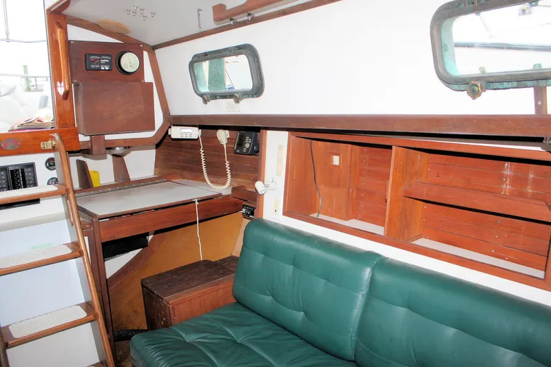 Slide: The Image of 1987 Morris Linda boat interior with green seating, wooden shelves, and navigation equipment. - 41