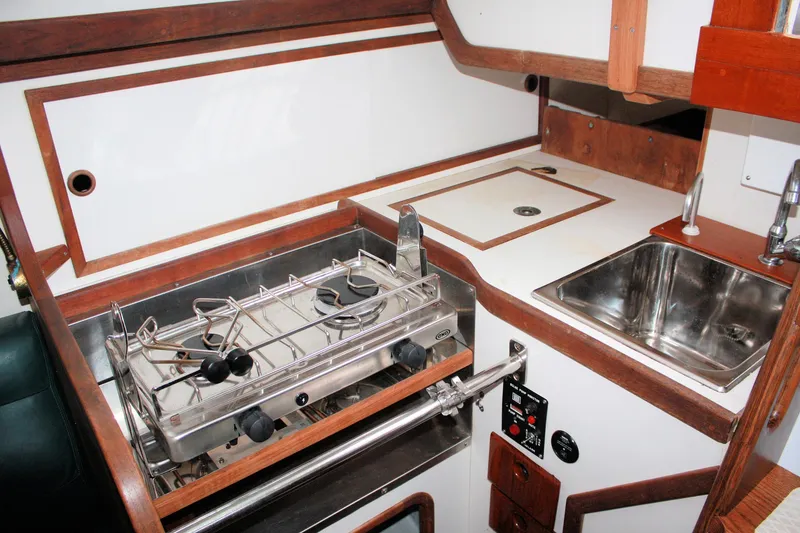 Slide: The Image of 1987 Morris Linda yacht kitchen with stove, sink, and wooden cabinetry. - 43