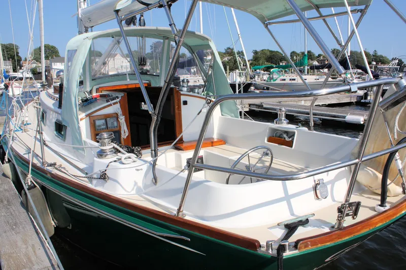 Slide: The Image of 1987 Morris Linda sailboat docked at a marina, showcasing its elegant design and spacious cockpit. - 7