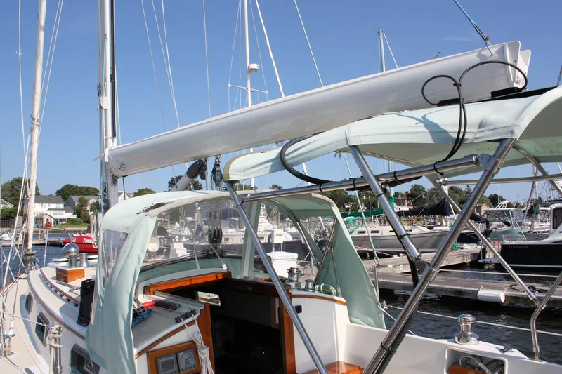 Slide: The Image of 1987 Morris Linda sailboat docked at a marina, featuring a sleek design and spacious cockpit. - 9