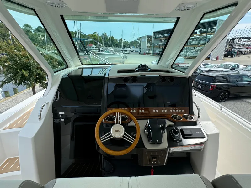 Slide: The Image of 2025 Tiara Yachts 34 LS helm with modern controls and panoramic marina view. - 18