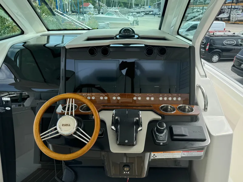Slide: The Image of 2025 Tiara Yachts 34 LS helm with modern controls and wooden steering wheel. - 19