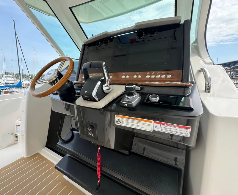Slide: The Image of 2025 Tiara Yachts 34 LS helm with modern controls and wooden steering wheel. - 20