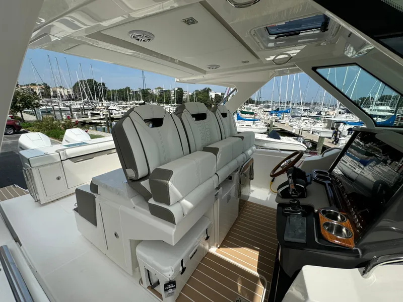 Slide: The Image of 2025 Tiara Yachts 34 LS interior with luxurious seating and modern dashboard at marina. - 24