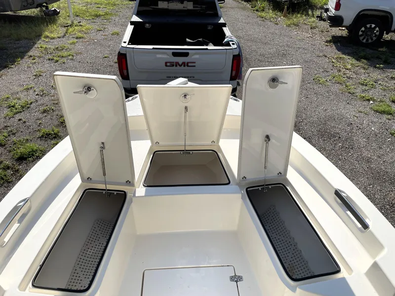 Slide: The Image of Open storage compartments on a 2021 Pathfinder 2005 TRS boat, with a GMC truck nearby. - 23