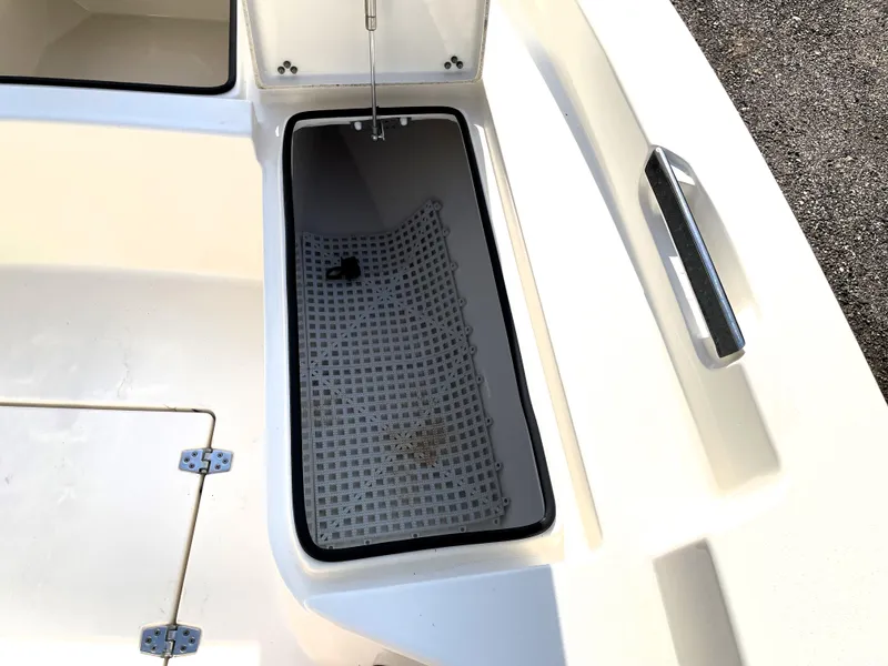 Slide: The Image of Open storage compartment on a 2021 Pathfinder 2005 TRS boat, featuring a grid mat. - 26
