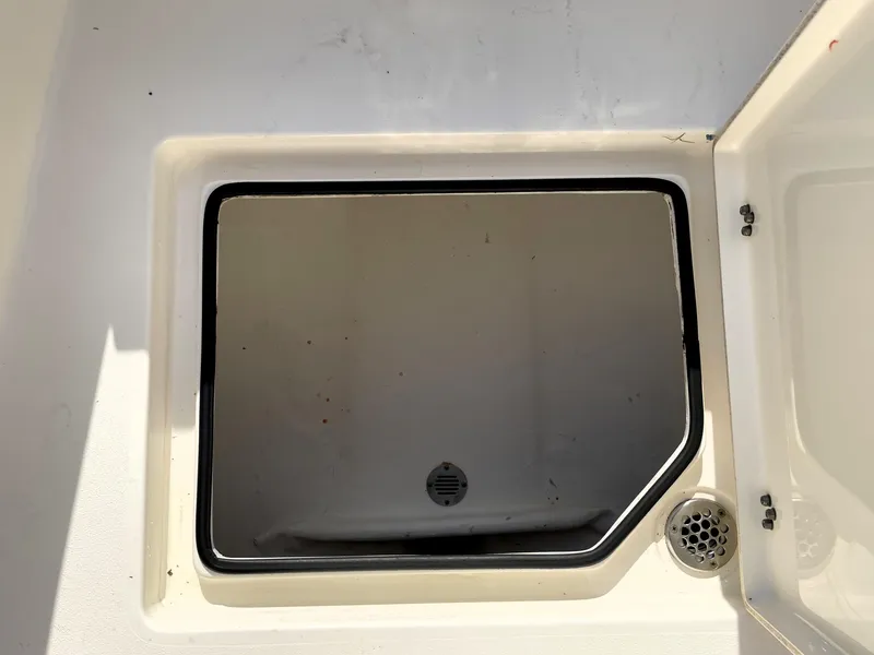 Slide: The Image of Open storage compartment on a 2021 Pathfinder 2005 TRS boat, featuring a drain. - 29