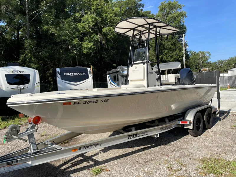 Slide: The Image of Pathfinder 2005 TRS boat on trailer, parked outdoors, surrounded by trees and RVs. - 5