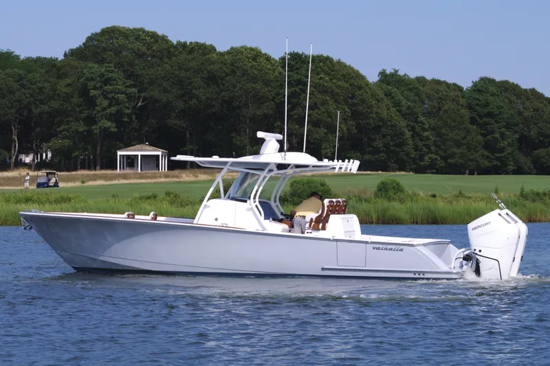 Slide: The Image of 2025 Valhalla Boatworks V-33 cruising on a serene lake with lush greenery. - 10