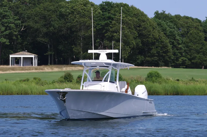 Slide: The Image of 2025 Valhalla Boatworks V-33 cruising on a serene lake with lush greenery. - 12