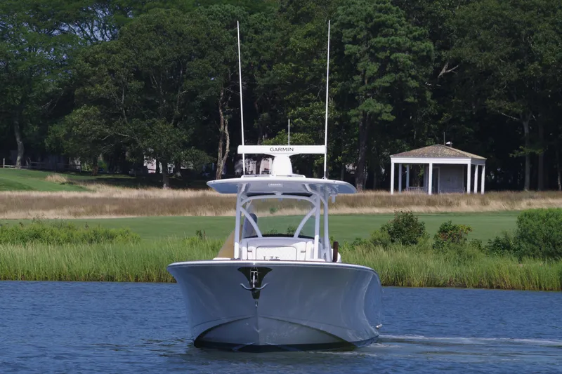 Slide: The Image of 2025 Valhalla Boatworks V-33 cruising on a serene lake with lush greenery. - 13