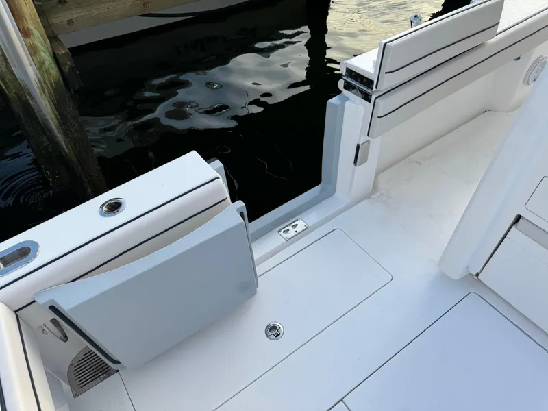 Slide: The Image of 2025 Valhalla Boatworks V-33 deck with sleek seating and storage near water. - 27