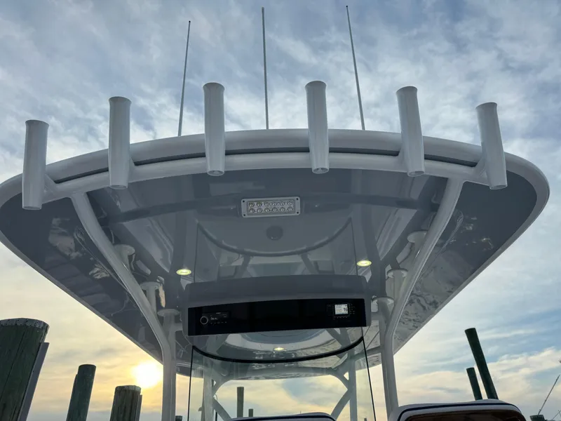 Slide: The Image of 2025 Valhalla Boatworks V-33, view of the boat's T-top and rod holders at sunset. - 28