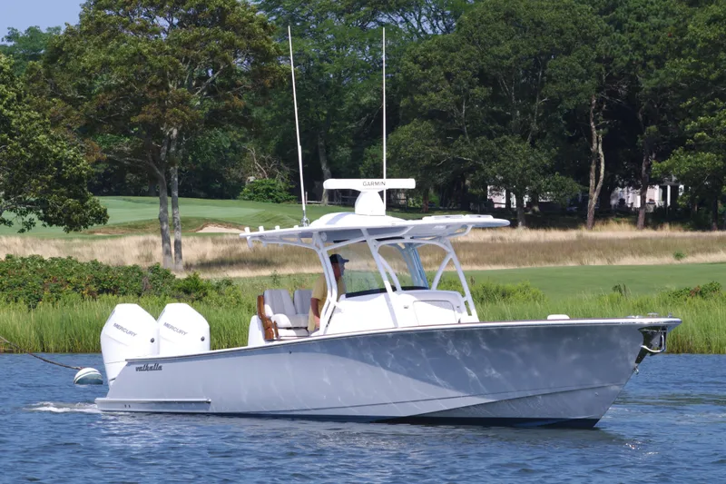 Slide: The Image of 2025 Valhalla Boatworks V-33 cruising on a serene lake with lush greenery. - 4