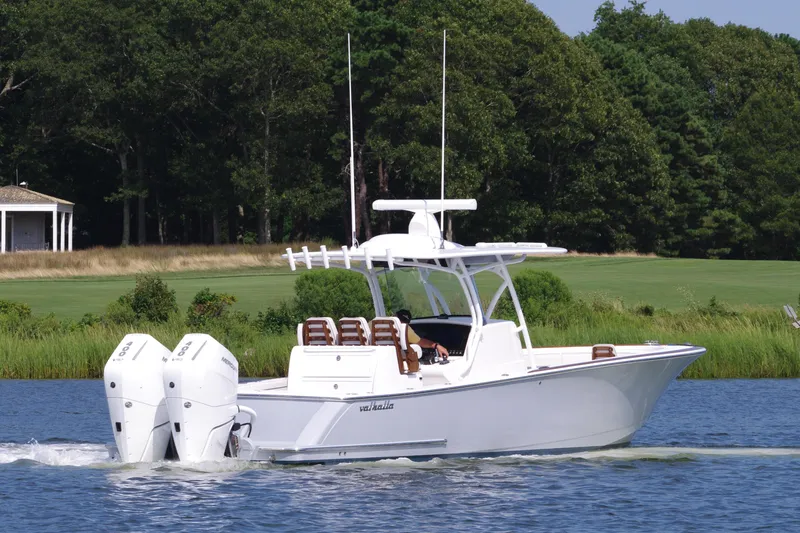 Slide: The Image of 2025 Valhalla Boatworks V-33 cruising on a serene lake with lush greenery. - 6