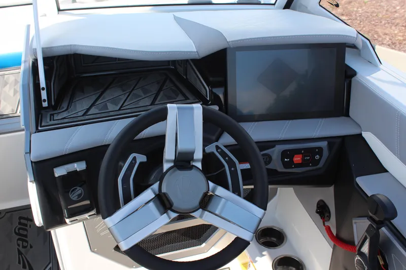 Slide: The Image of 2024 Tigé Ultré 25ZX boat dashboard with modern steering wheel and touchscreen display. - 16