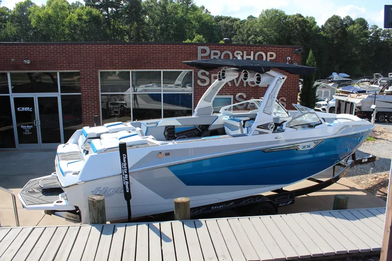 Slide: The Image of 2024 Tigé Ultré 25ZX boat displayed outside a pro shop. - 5