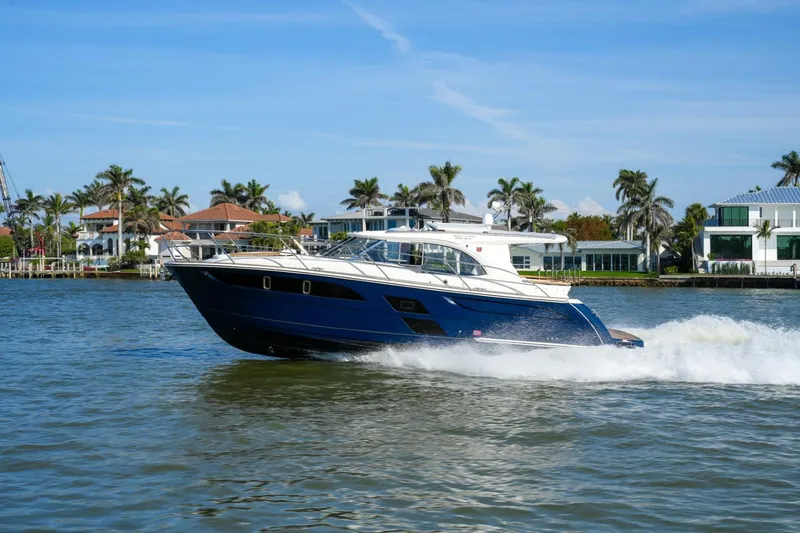 Slide: The Image of 2025 Marex 360 Cabriolet Cruiser sailing on a sunny day near waterfront homes. - 4