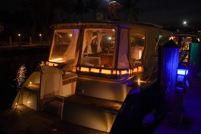 Slide: The Image of 2025 Marex 360 Cabriolet Cruiser illuminated at night, docked with ambient lighting. - 28