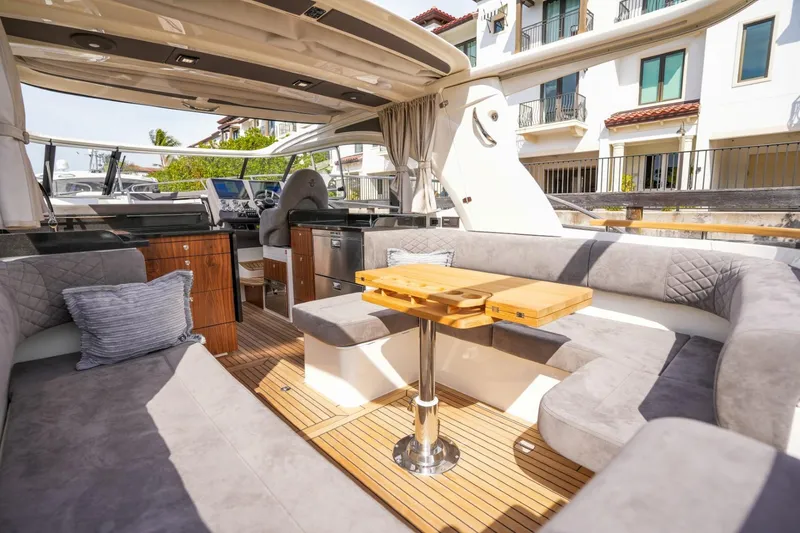 Slide: The Image of 2025 Marex 360 Cabriolet Cruiser interior with plush seating and wooden table. - 15