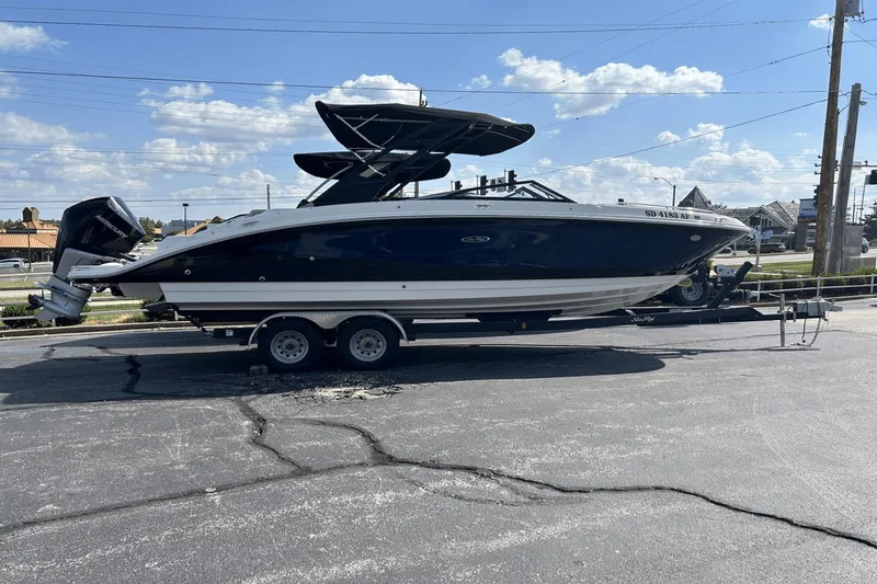 Slide: The Image of 2022 Sea Ray 270 Sundeck Outboard boat on trailer under blue sky. - 0