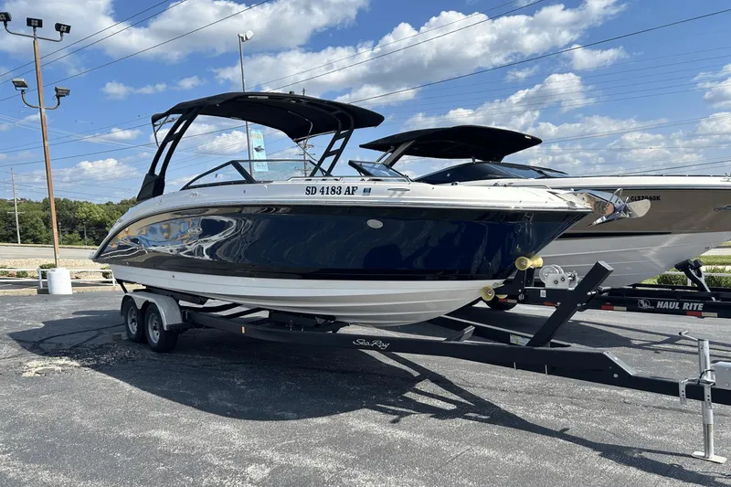 Slide: The Image of 2022 Sea Ray 270 Sundeck Outboard boat on trailer under blue sky. - 1