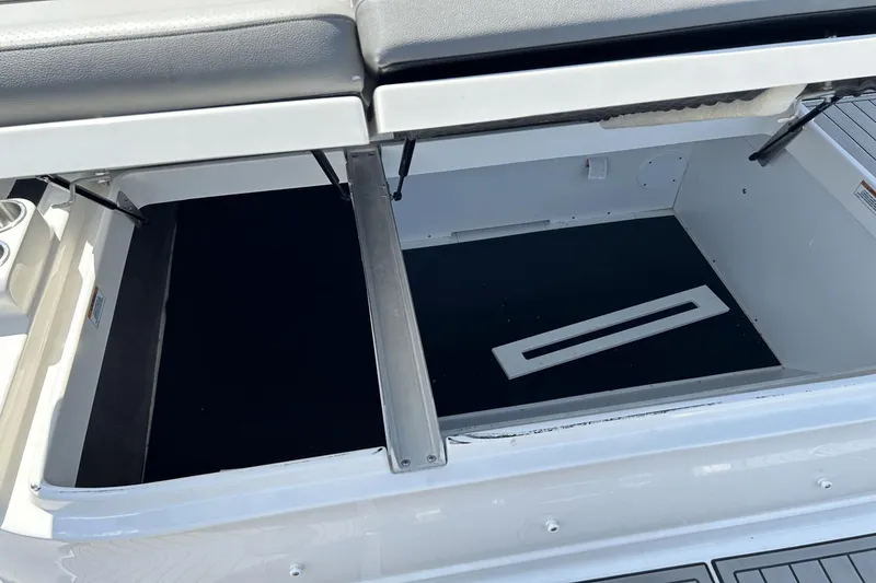 Slide: The Image of 2022 Sea Ray 270 Sundeck Outboard storage compartment with open lid and cushioned seating. - 12
