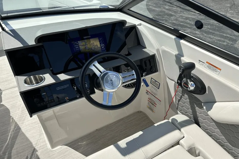 Slide: The Image of 2022 Sea Ray 270 Sundeck Outboard helm with steering wheel and control panel. - 14