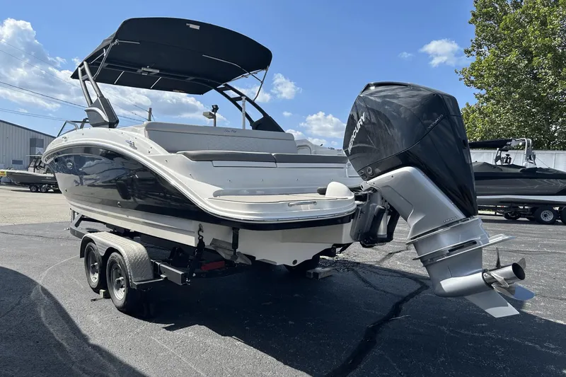 Slide: The Image of 2022 Sea Ray 270 Sundeck Outboard on trailer, parked outdoors under clear sky. - 3