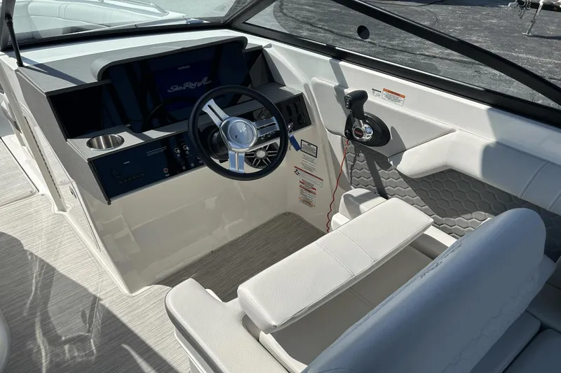 Slide: The Image of 2022 Sea Ray 270 Sundeck Outboard helm with steering wheel and controls. - 9