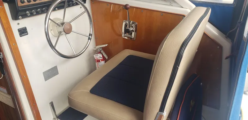 Slide: The Image of 1977 Chris-Craft 28' Cruiser helm with steering wheel and beige seat. - 14