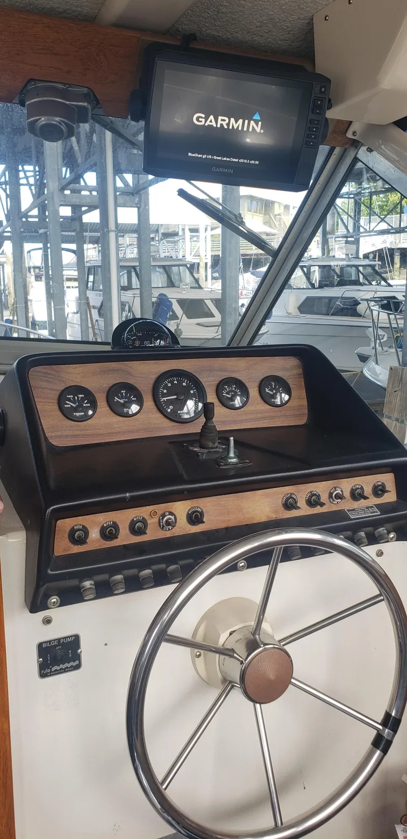 Slide: The Image of 1977 Chris-Craft 28' Cruiser helm with Garmin navigation, classic gauges, and steering wheel. - 15