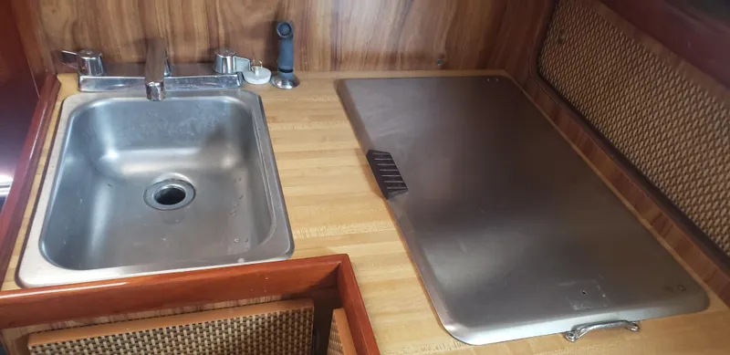 Slide: The Image of 1977 Chris-Craft 28' Cruiser kitchen sink and countertop with wood finish. - 25