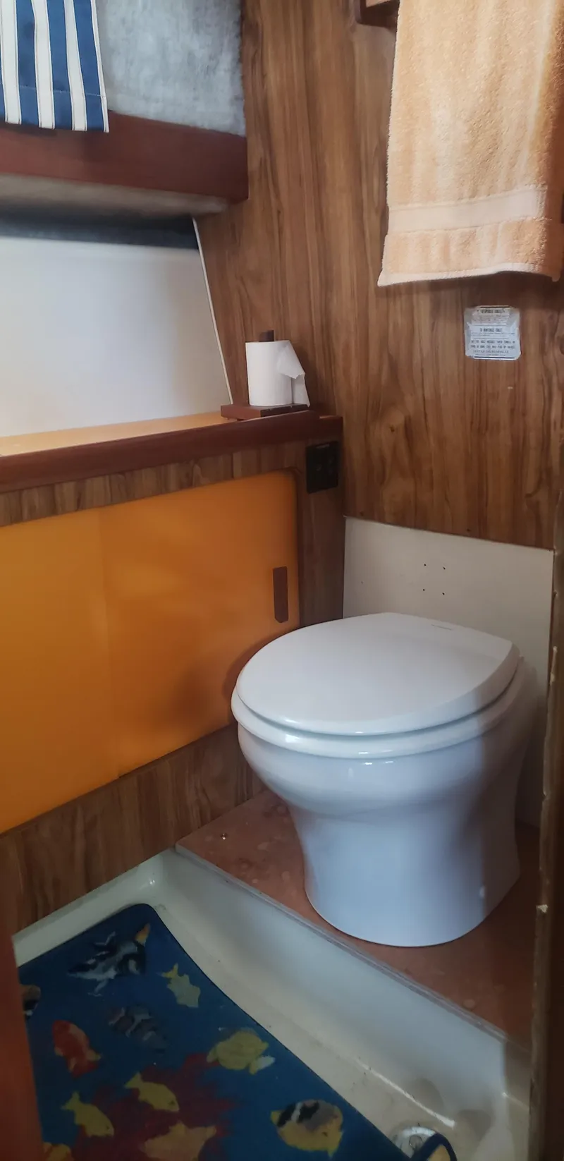 Slide: The Image of 1977 Chris-Craft 28' Cruiser bathroom with wood paneling and nautical decor. - 28