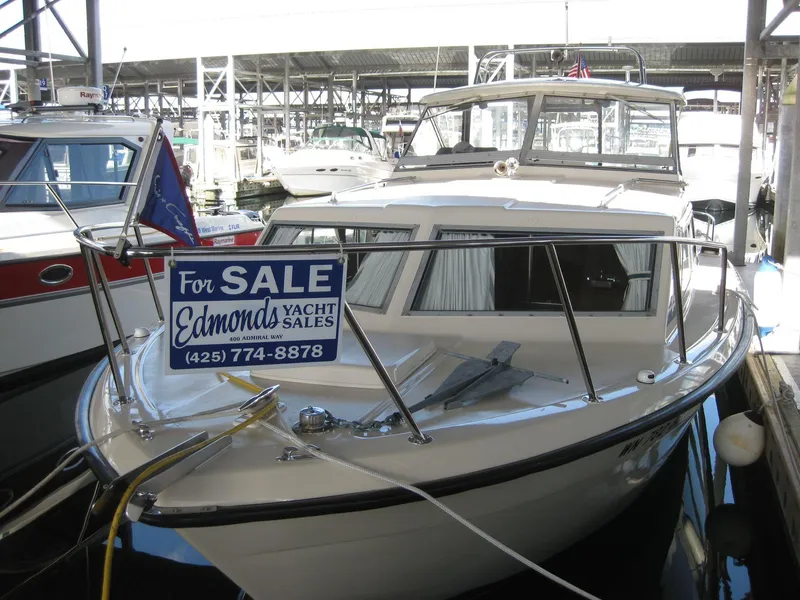 Slide: The Image of 1977 Chris-Craft 28' Cruiser for sale at marina, Edmonds Yacht Sales sign visible. - 3