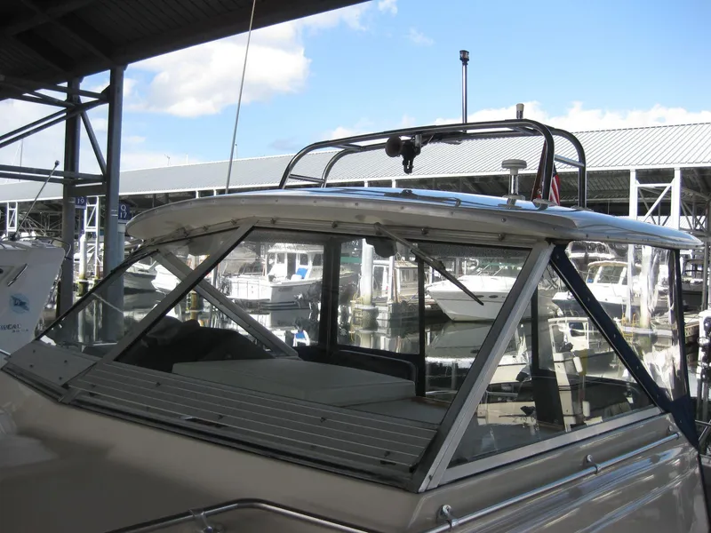 Slide: The Image of 1977 Chris-Craft 28' Cruiser docked at a marina under a clear sky. - 4