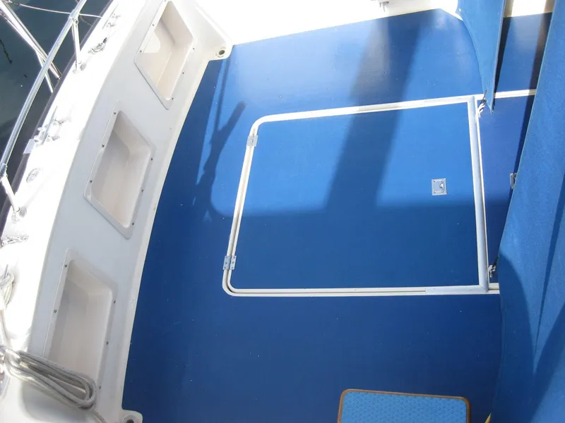 Slide: The Image of 1977 Chris-Craft 28' Cruiser deck with blue flooring and storage compartments. - 5