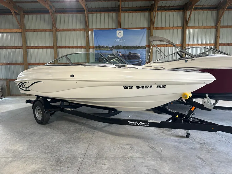 The Image of 1999 Rinker 212 Bowrider Captiva boat on trailer in storage facility. - 13