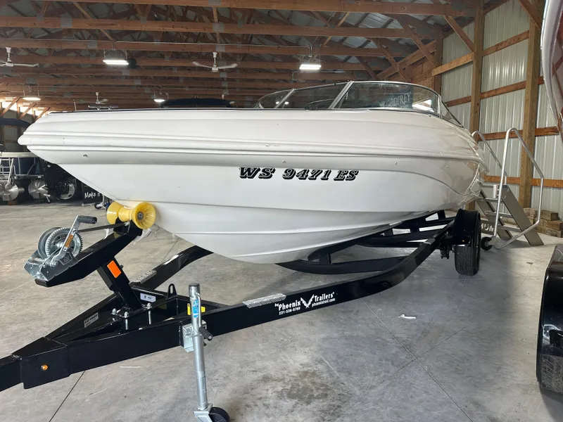 Slide: The Image of 1999 Rinker 212 Bowrider Captiva boat on trailer in a storage facility. - 15