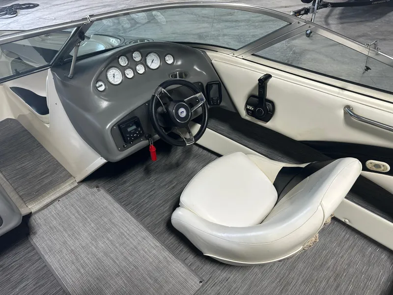 Slide: The Image of 1999 Rinker 212 Bowrider Captiva boat interior with steering wheel and dashboard controls. - 20