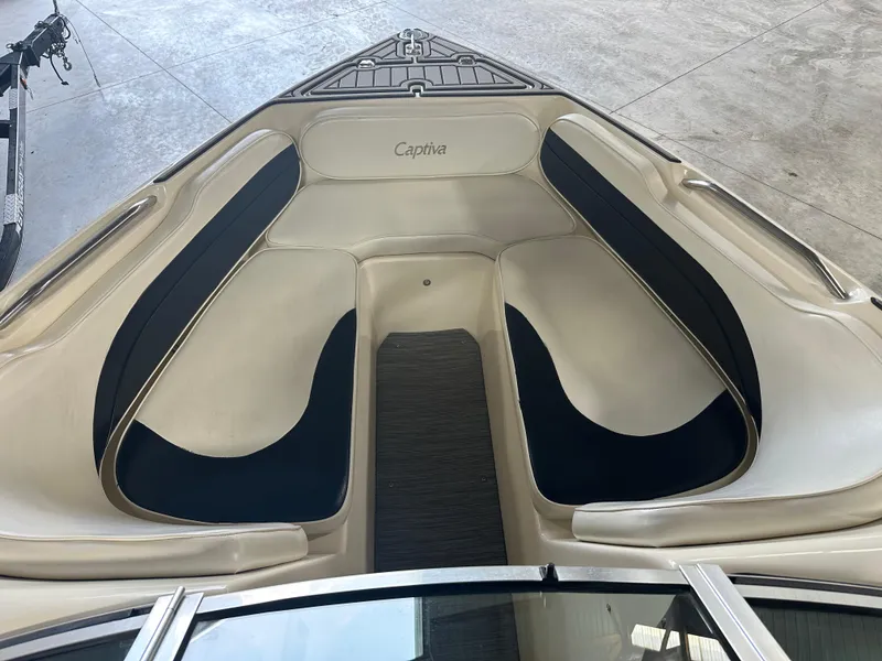 Slide: The Image of 1999 Rinker 212 Bowrider Captiva boat interior with beige and black seating. - 24